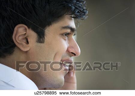 Young man talking on a mobile phone View Large Photo Image Stock Photography - Young man talking on a mobile phone . Fotosearch