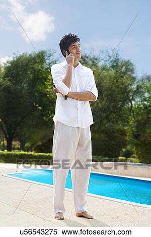 Young man talking on a mobile phone View Large Photo Image Stock Photography - Young man talking on a mobile phone . Fotosearch