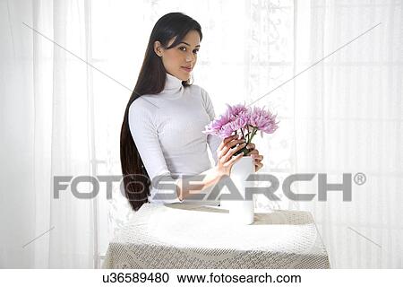 Young woman arranging flowers in a vase View Large Photo Image Stock Image - Young woman arranging flowers in a vase . Fotosearch