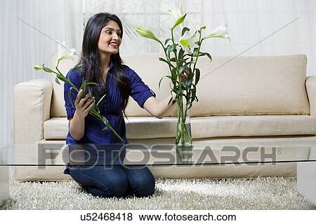 Young woman arranging flowers in a vase View Large Photo Image Stock Photo - Young woman arranging flowers in a vase . Fotosearch