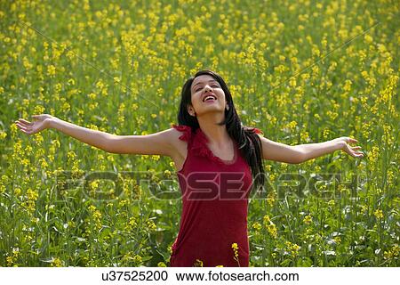 Young woman enjoying herself in a field View Large Photo Image Stock Image - Young woman enjoying herself in a field . Fotosearch