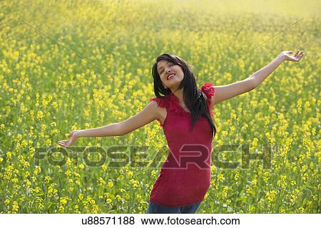 Young woman enjoying herself in a field View Large Photo Image Stock Photo - Young woman enjoying herself in a field . Fotosearch
