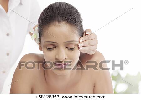 Stock Image - Young woman getting head massage at spa . Fotosearch