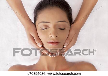 Stock Photograph - Young woman having face massage . Fotosearch
