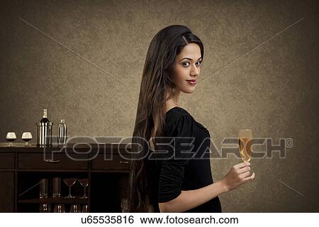 Young woman holding a glass of wine View Large Photo Image Stock Photograph - Young woman holding a glass of wine . Fotosearch