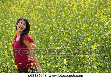 Stock Photo - Young woman in a field . Fotosearch