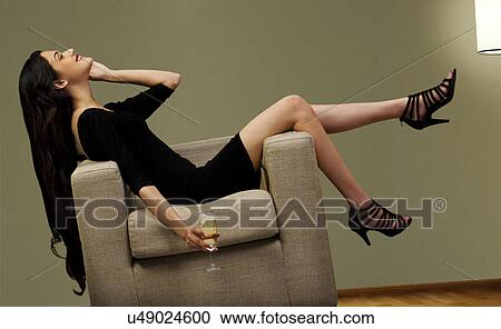 Young woman on a couch with a glass of wine View Large Photo Image Stock Image - Young woman on a couch with a glass of wine . Fotosearch