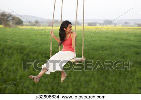 Picture - Young woman on a swing . Fotosearch