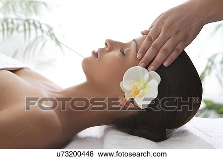 Young woman on massage table getting head massage View Large Photo Image Stock Photo - Young woman on massage table getting head massage . Fotosearch