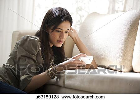 Young woman reading an sms View Large Photo Image Stock Photo - Young woman reading an sms . Fotosearch