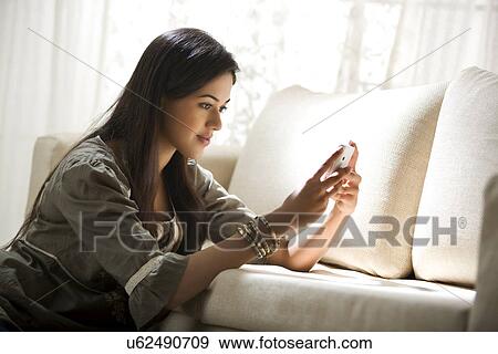 Young woman sending a text message View Large Photo Image Stock Photo - Young woman sending a text message . Fotosearch