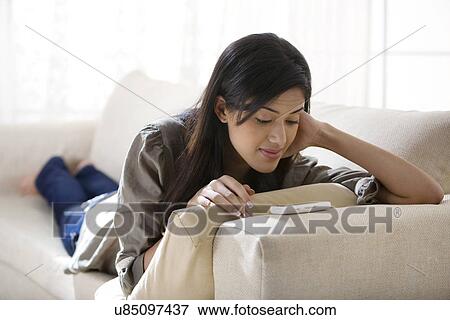 Stock Photo - Young woman watching a video on her mobile phone . Fotosearch