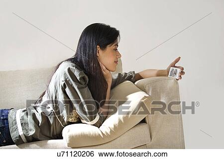 Stock Photograph - Young woman watching a video on her mobile phone . Fotosearch