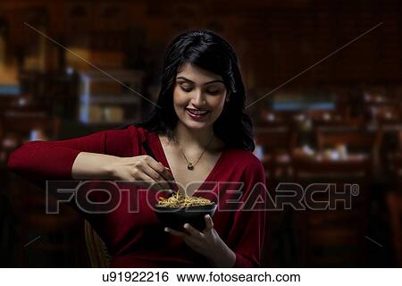 Stock Photograph - Young woman with a bowl of noodles . Fotosearch