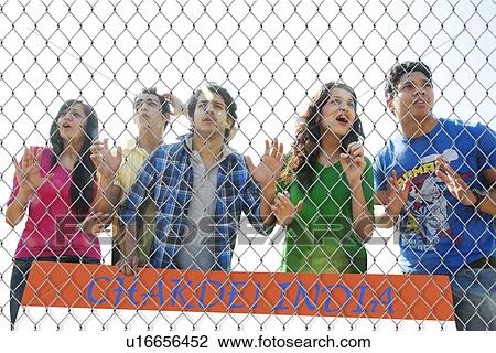 Youngsters watching a match through a wire mesh View Large Photo Image Stock Image - Youngsters watching a match through a wire mesh . Fotosearch