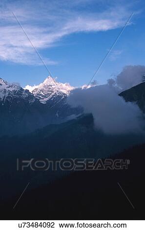 Snow capped mountains with clouds View Large Photo Image Stock Image - Snow capped mountains with clouds. Fotosearch