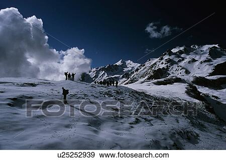 Snow capped mountains with clouds View Large Photo Image Stock Photo - Snow capped mountains with clouds. Fotosearch