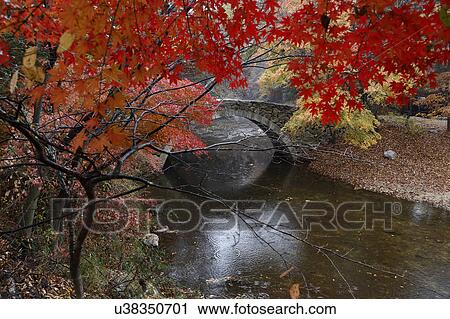 Stock Image - Autumn color and old stone arched bridge at Namsangol traditional folk village, Seoul, South Korea. Fotosearch