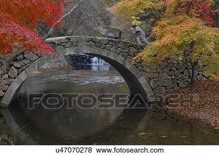 Stock Photo - Autumn color and old stone arched bridge at Namsangol traditional folk village, Seoul, South Korea. Fotosearch