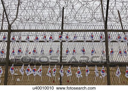Barbed wire fence separates South from North Korea - South Korean flags attached to fence - Asia- View Large Photo Image Stock Image - Barbed wire fence separates South from North Korea - South Korean flags attached to fence - Asia- . Fotosearch
