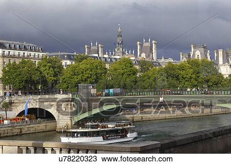 Stock Image - Bridge over the River Seine and tour boat on summer day, Paris, France. Fotosearch