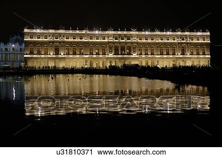 Stock Image -  Chateau de Versailles at night with lights, the estate of Versaille was the home and court of Louis XIV, France. Fotosearch