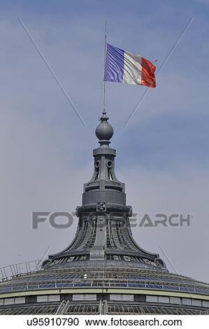 Stock Image - French Flag flies over the Glass roof of the Grand Palais, Paris. France. Fotosearch