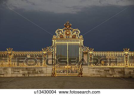 Picture - Golden entry gates of Chateau De Versailles with setting sunlight, France. Fotosearch