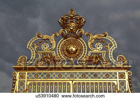 Stock Image - Golden entry gates of Chateau De Versailles with setting sunlight, France. Fotosearch
