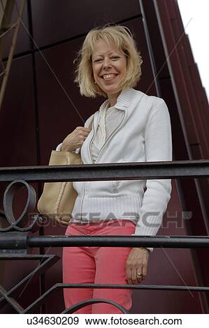 Stock Photo - Leslie Plimpton smiles from top of steps at Eiffel Tower, Paris, France. Fotosearch