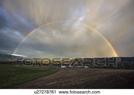 Stock Image - Oak View, California, USA, March 1, 2015, full rainbow over rain storm in Ojai Valley. Fotosearch