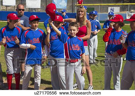 Stock Photograph - Oak View, California, USA, March 7, 2015, Ojai Valley Little League Field, youth Baseball, Spring, raise their caps when name is announced. Fotosearch