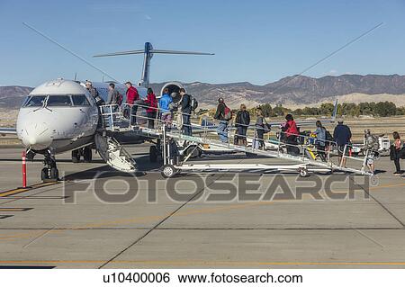 Passengers climbing stairs to board airplane Santa Barbara, CA View Large Photo Image Stock Photograph - Passengers climbing stairs to board airplane Santa Barbara, CA. Fotosearch