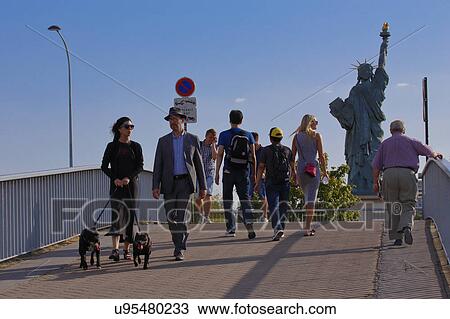 Stock Image - People view Replica of the Statue of Liberty, view from the River Seine - Paris, France. Fotosearch