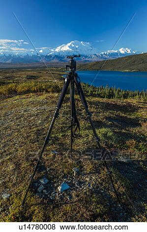 Stock Photo - Photographer Joe Sohm tripod poses at famous Ansel Adams picture spot, Wonder Lake, Mount Denali, Kantishna, Alaska. Fotosearch