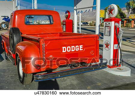 Stock Image - Red Dodge Pickup truck parked in front of vintage gas station in Santa Paula, California. Fotosearch