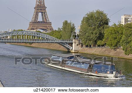 Stock Photo - Replica of the Statue of Liberty and Eiffel Tower with tourboat on River Seine - Paris, France. Fotosearch