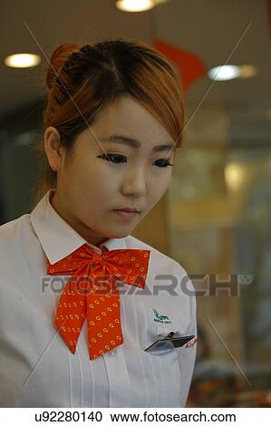 Stock Image - South Korea, National Capital Area, Seoul, waitress working at Seoul Cafe. Fotosearch