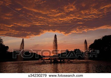 Stock Photo - The Grand Canal Fountains of Chateau de Versailles at sunset, the estate of Versaille home of Louis XIV, France. Fotosearch