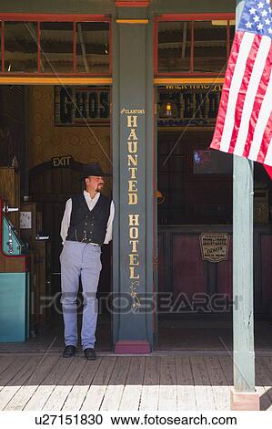 Stock Image - Tombstone, Arizona, USA, April 6, 2015, cowboy and flag in old western town home of Doc Holliday and Wyatt Earp and Gunfight at the O. K. Corral. Fotosearch