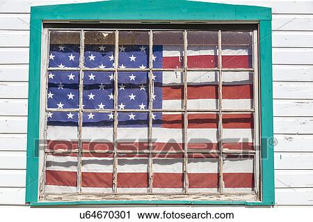 Stock Image - US Flag hangs on old house outside of Ouray, Colorado, Route 550. Fotosearch