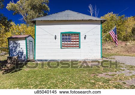 Stock Photography - US Flag hangs on old house outside of Ouray, Colorado, Route 550. Fotosearch