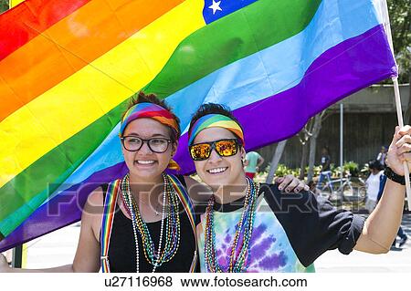 West Hollywood, Los Angeles, California, USA, June 14, 2015, 40th annual Gay Pride Parade for LGBT Community, down Santa Monica Blvd., two Lesbian women under gay rainbow flag smile View Large Photo Image Stock Photo - West Hollywood, Los Angeles, California, USA, June 14, 2015, 40th annual Gay Pride Parade for LGBT Community, down Santa Monica Blvd., two Lesbian women under gay rainbow flag smile. Fotosearch