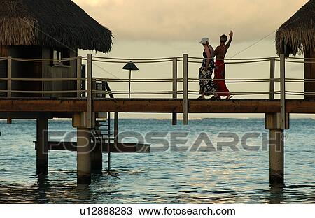 A mid adult couple walking on a pier, Moorea, Tahiti, French Polynesia, South Pacific View Large Photo Image Stock Image - A mid adult couple walking on a pier, Moorea, Tahiti, French Polynesia, South Pacific. Fotosearch