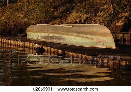 Stock Image - Canoe upside down on dock. Fotosearch