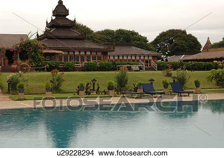 Picture - Lounge chairs at edge of pool. Fotosearch