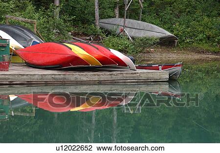 Stock Image - View of a boats on a pier besides a lake, Rocky Mountains, Canada. Fotosearch