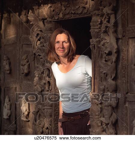 Woman standing in wall opening at Buddhist Monastery View Large Photo Image Stock Photography - Woman standing in wall opening at Buddhist Monastery. Fotosearch