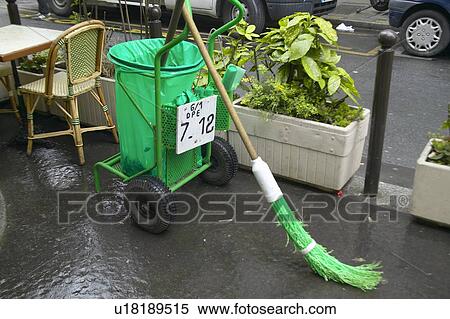 Stock Photography - Green broom and garbage pail on street, Paris, France. Fotosearch