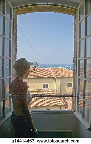 Stock Photo - Woman looking out of museum. Fotosearch